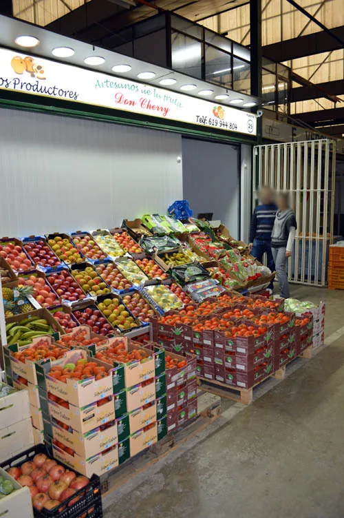 Pasillo del puesto con cajas de fruta y verdura